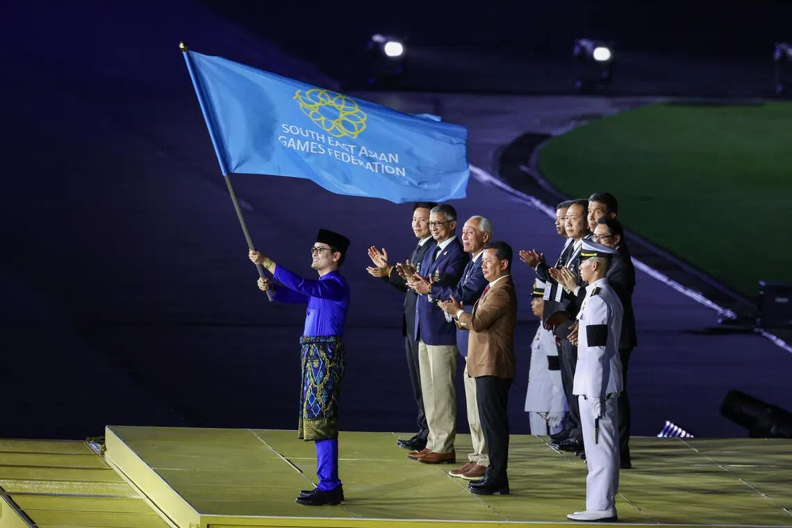 马来西亚新任青年及体育部长道菲克佐哈里挥动着东运会旗帜，2027年东运会将在马国四个地区举行。（白艳琳摄）