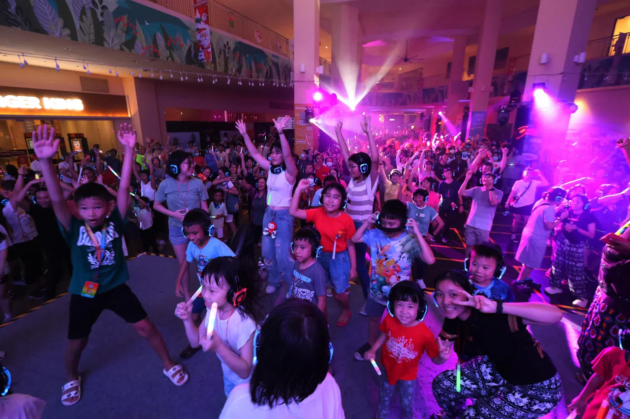 在勿洛心动大厦参加跨年活动的公众各个戴上耳机手舞足蹈，沉浸于欢乐的气氛。（梁麒麟摄）