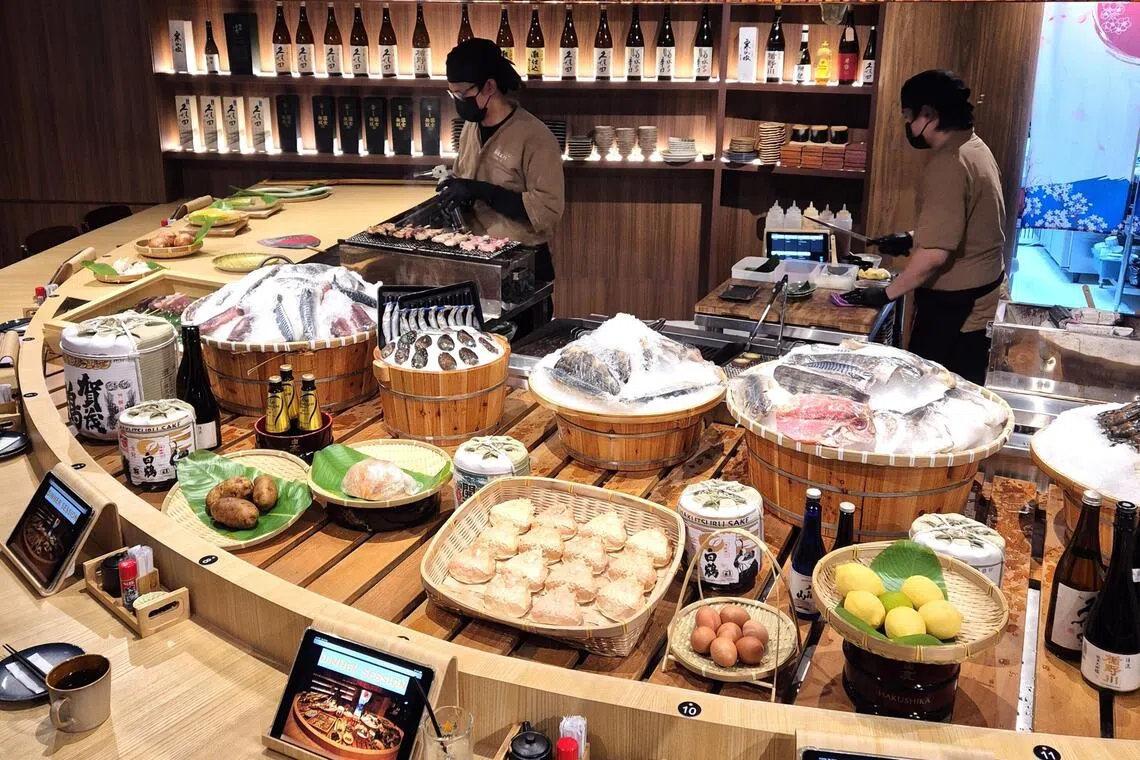 坐在吧前的食客，可以近距离欣赏师傅精湛的炭火烧烤技艺。（陈爱薇摄）