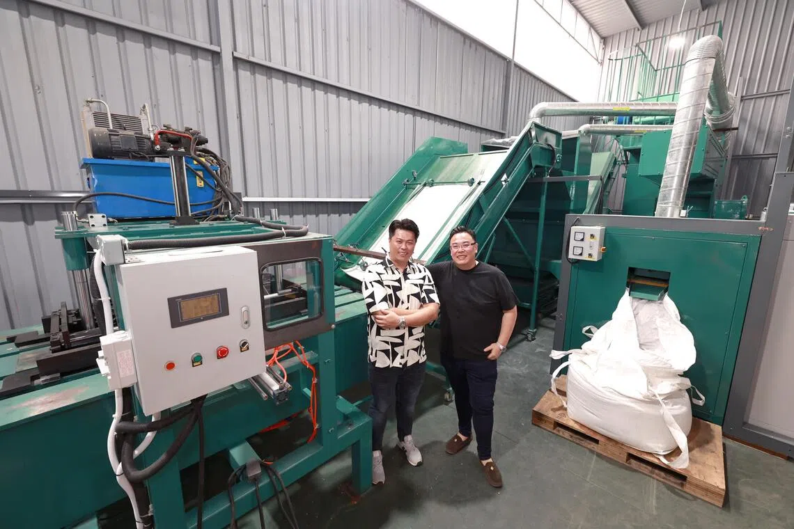 Redux执行董事谢粮全（左）和弟弟、Redux业务发展董事谢粮有，向记者介绍今年9月引进的太阳能板回收机。（周国威摄）