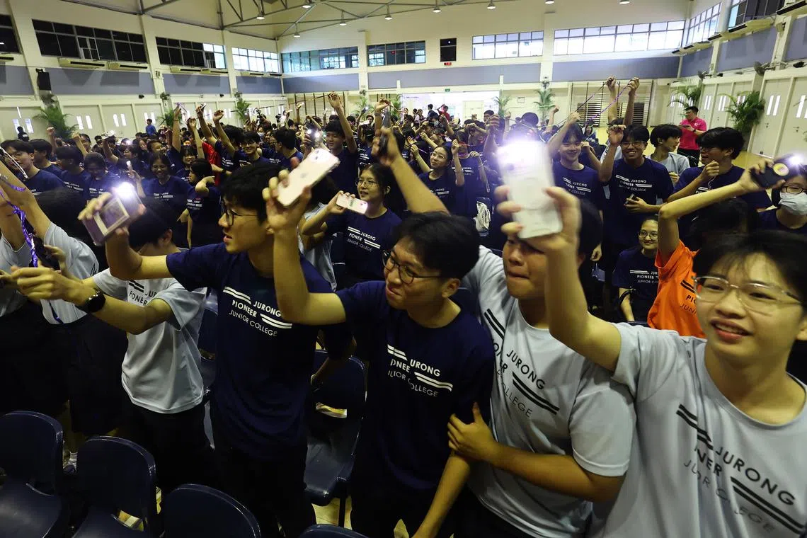 学生纷纷起立，打开闪光一起合唱。（陈渊庄摄）