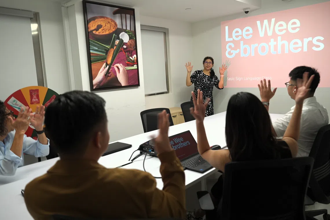 罗淑凤教导同事们基本手语。（视频截图）