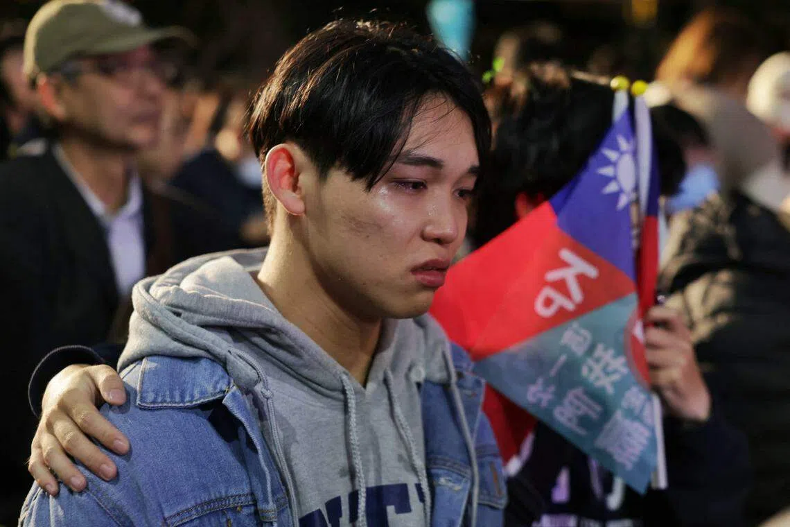 柯文哲的得票率在开票后持续落后，在民众党竞选总部等候选举成绩的一名年轻支持者伤心落泪。（法新社）