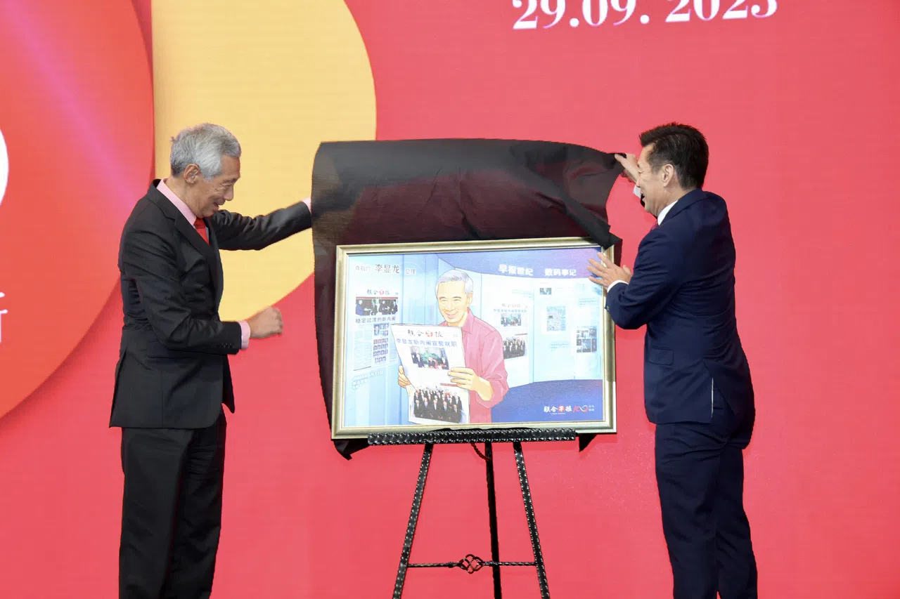 《联合早报》总编辑吴新迪为李显龙总理献上由早报视觉部构思的特殊数码画作。作品中有李总理出生日1952年2月10日的《南洋商报》和《星洲日报》封面；他手上拿着的则是2004年8月13日的《联合早报》，封面是他出任总理时组建的新内阁合照。（邝启聪摄）