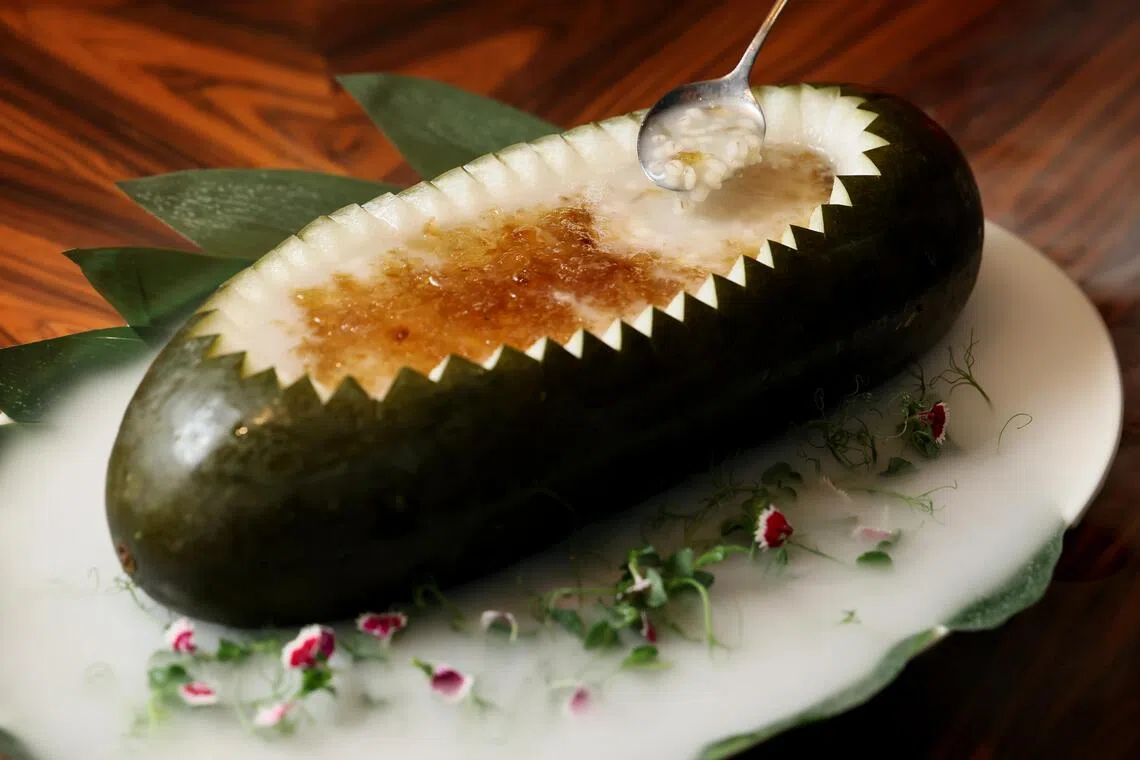 曾镜雄师傅将桃胶薏米藏在整颗大冬瓜里，出场气势十足。（龙国雄摄）