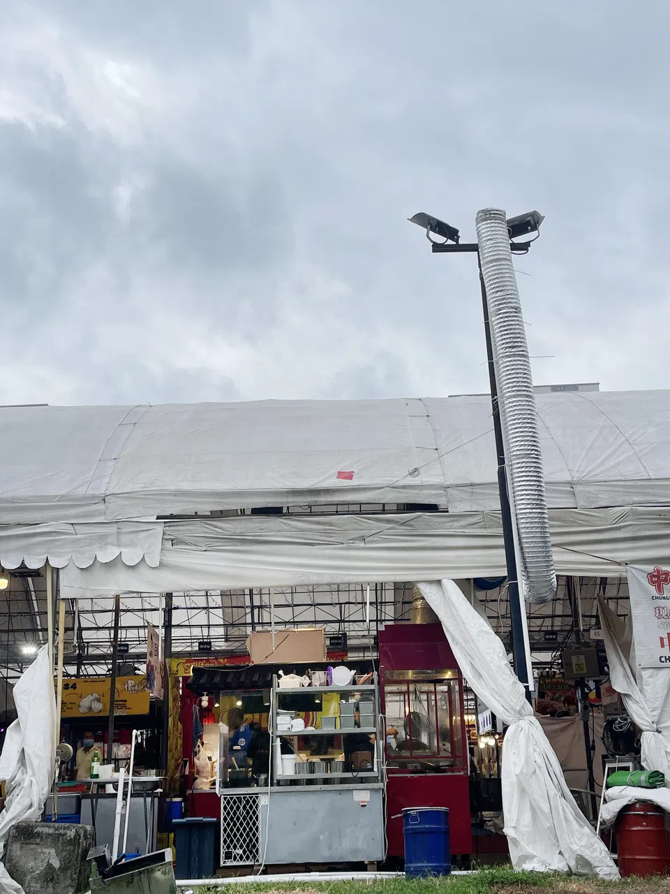 臭豆腐摊老板为解决问题，在摊位内安装了数米长的烟囱，把油烟和异味直接排到夜市外。（余明飞摄）