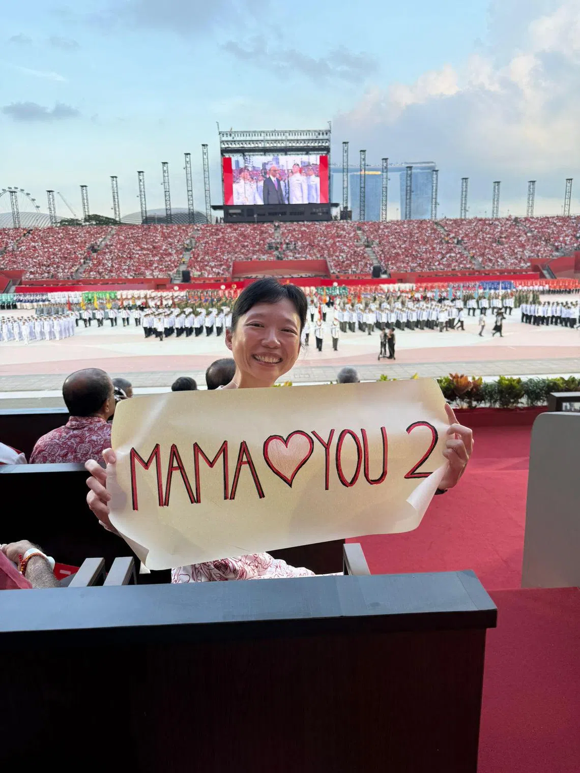 刘洁敏在今年国庆庆典上准备“妈妈也爱你”的横幅，向两个孩子隔空传达母爱。（受访者提供）