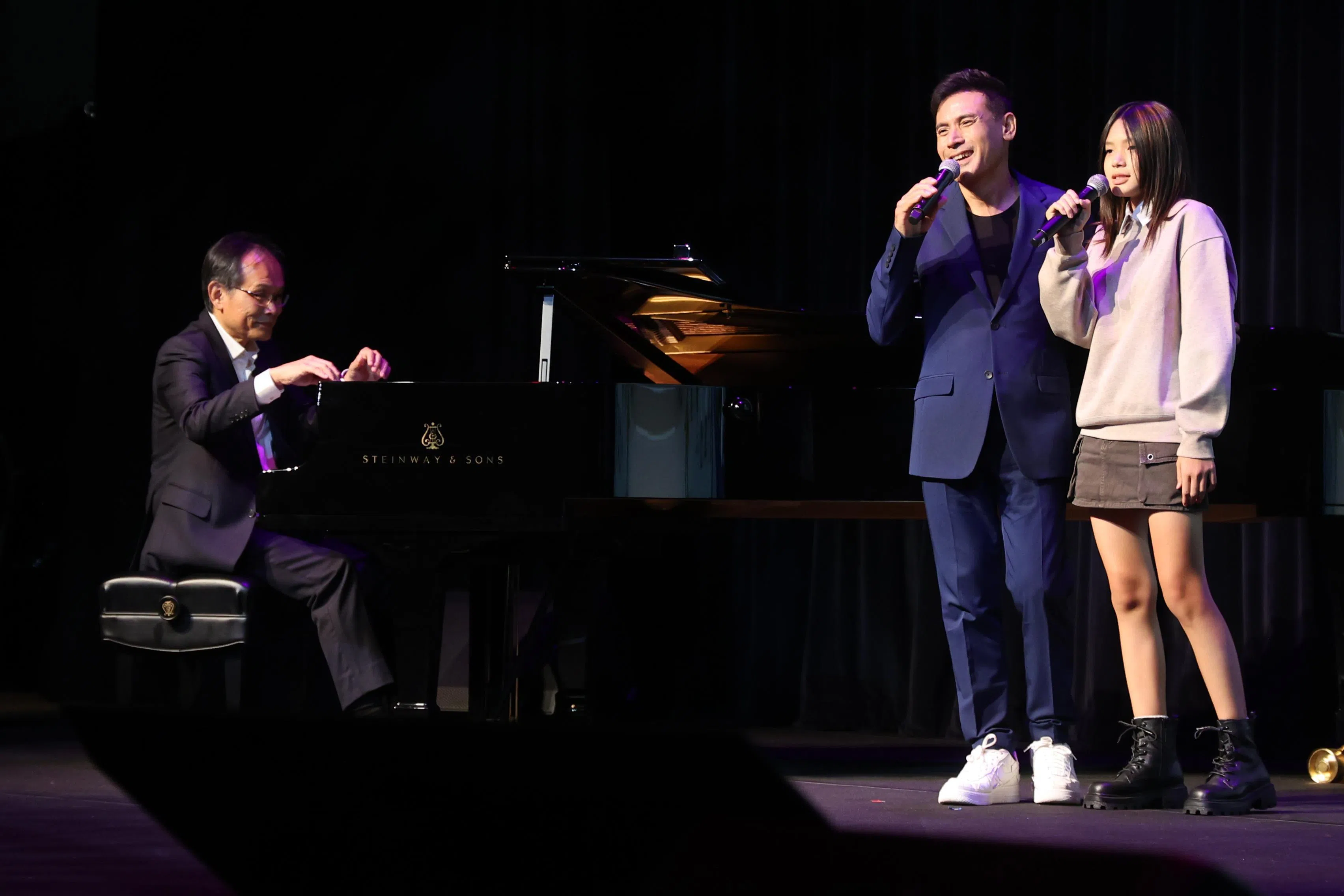 巫奇（中）和12岁的长女巫恩雅同台演唱，知名编曲人陈志群（左）为两人伴奏。（邝启聪摄）