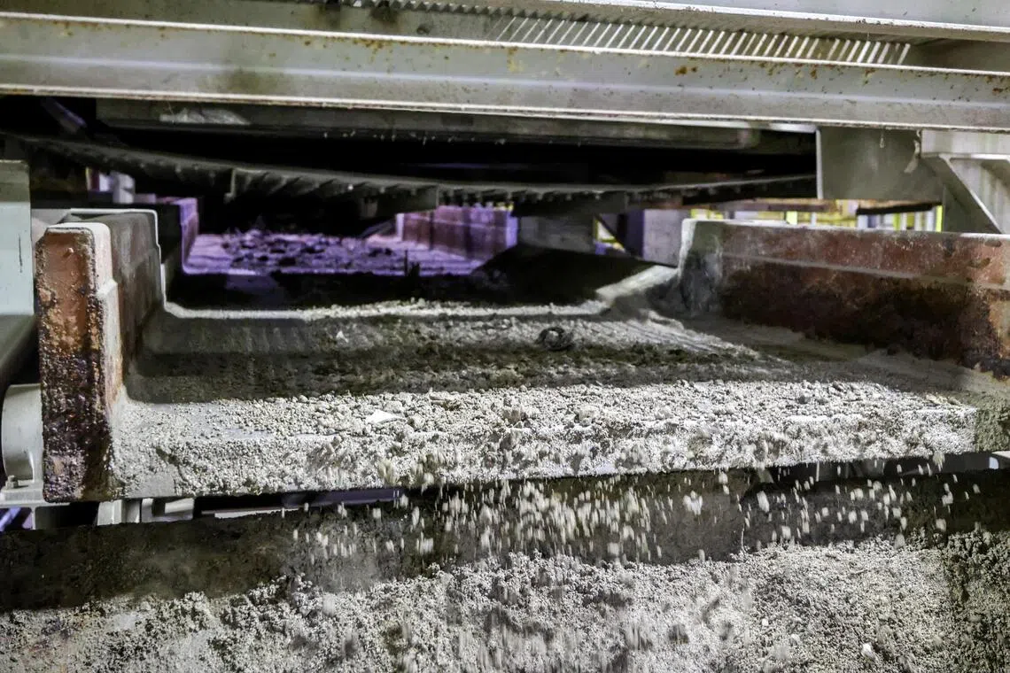 垃圾焚烧成灰烬后，会经过磁选机，尽量回收黑色废金属。（叶振忠摄）