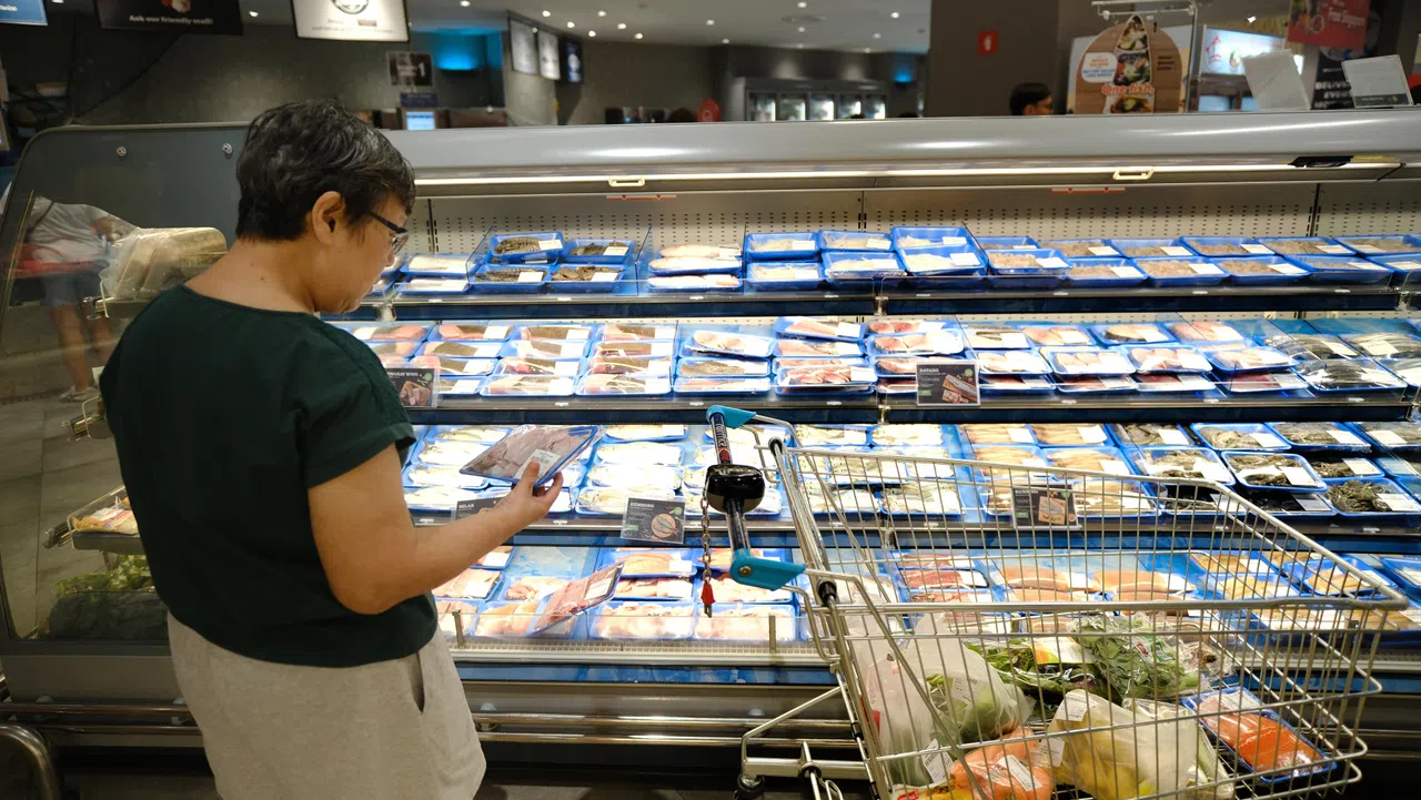 生活费高涨，人们购买食品和日用品不免要精打细算。（档案照片）