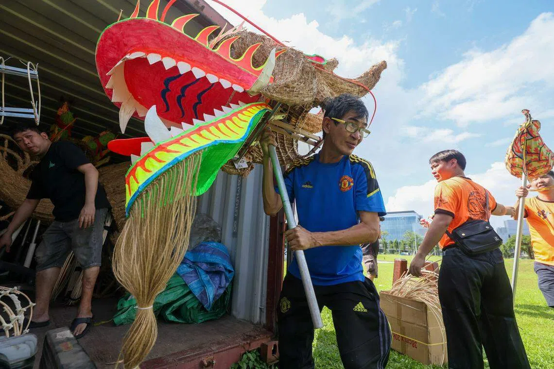 今年的妆艺大游行火龙演出后，沙冈万山福德祠醒狮团教练何伦良（蓝衣者）将与团员继续制作新的稻草火龙。（卓祾祎摄）