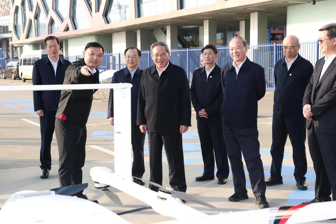 中共政治局常委、中国国务院总理李强（前排左二）星期天（1月4日）在深圳蛇口邮轮母港直升机场，了解低空经济发展情况。（新华社）