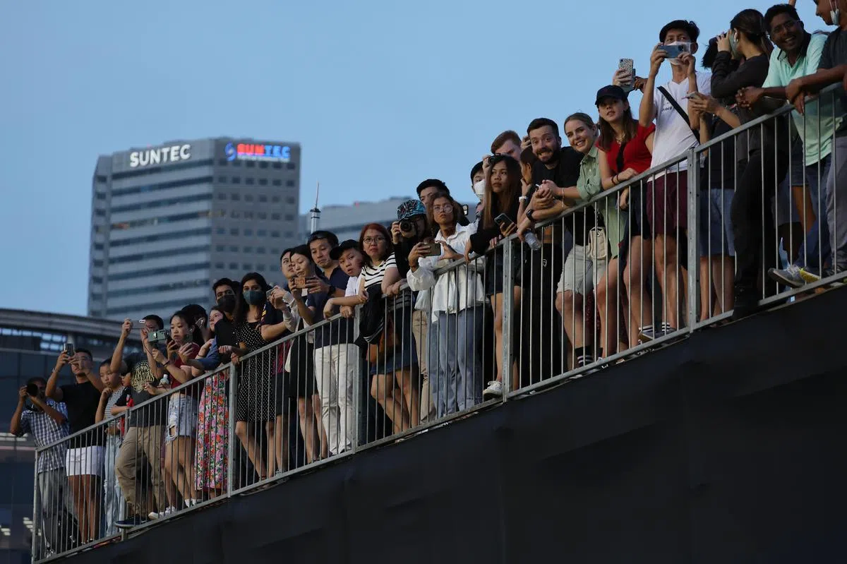 大批没有购票入场观赛的公众在滨海大道上驻足围观。（张思庆摄）
