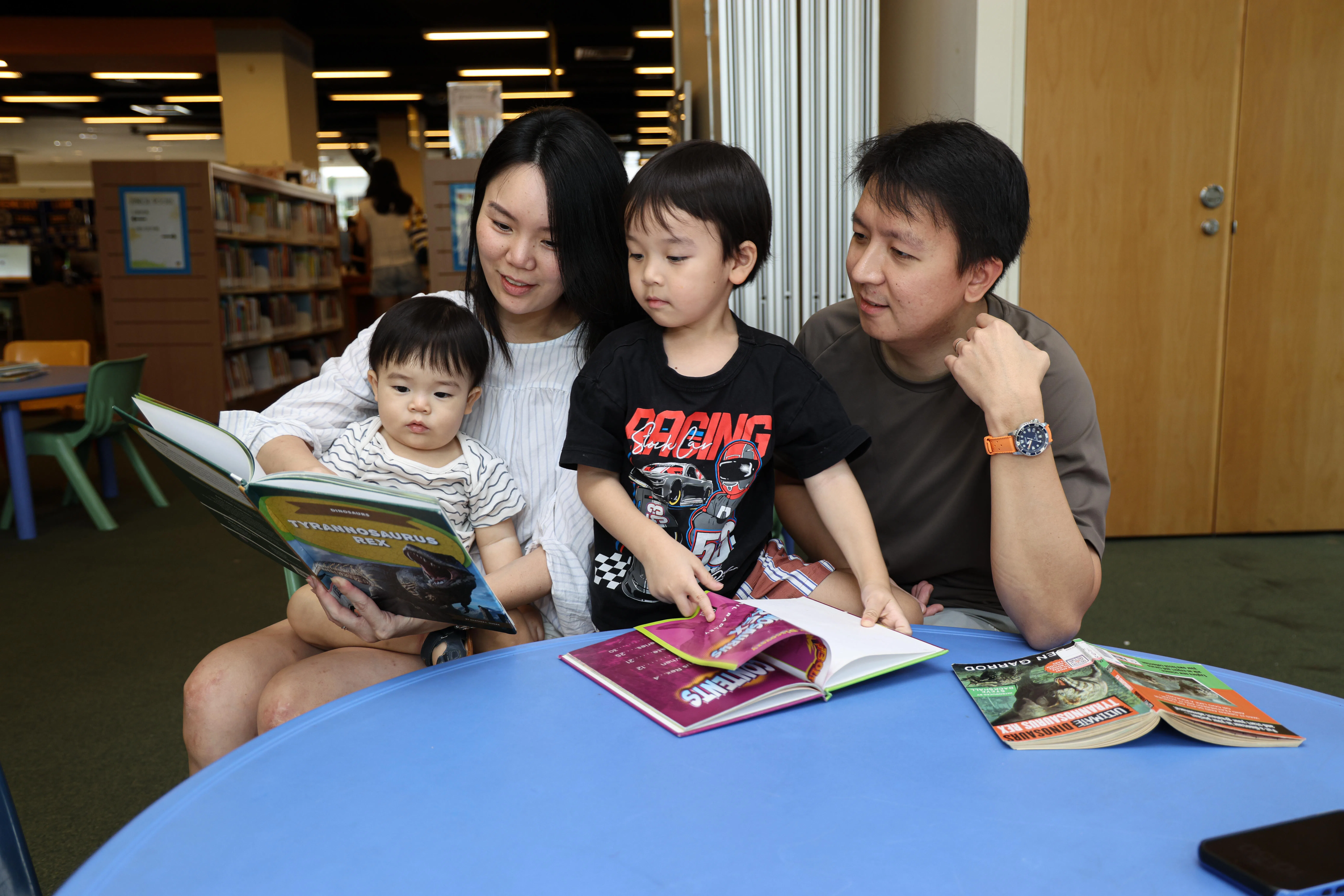 女皇镇图书馆翻新前最后一天，吴俊伟和张洁莹夫妇带着两个孩子，回到熟悉的图书馆给孩子们读故事。（关俊威摄）