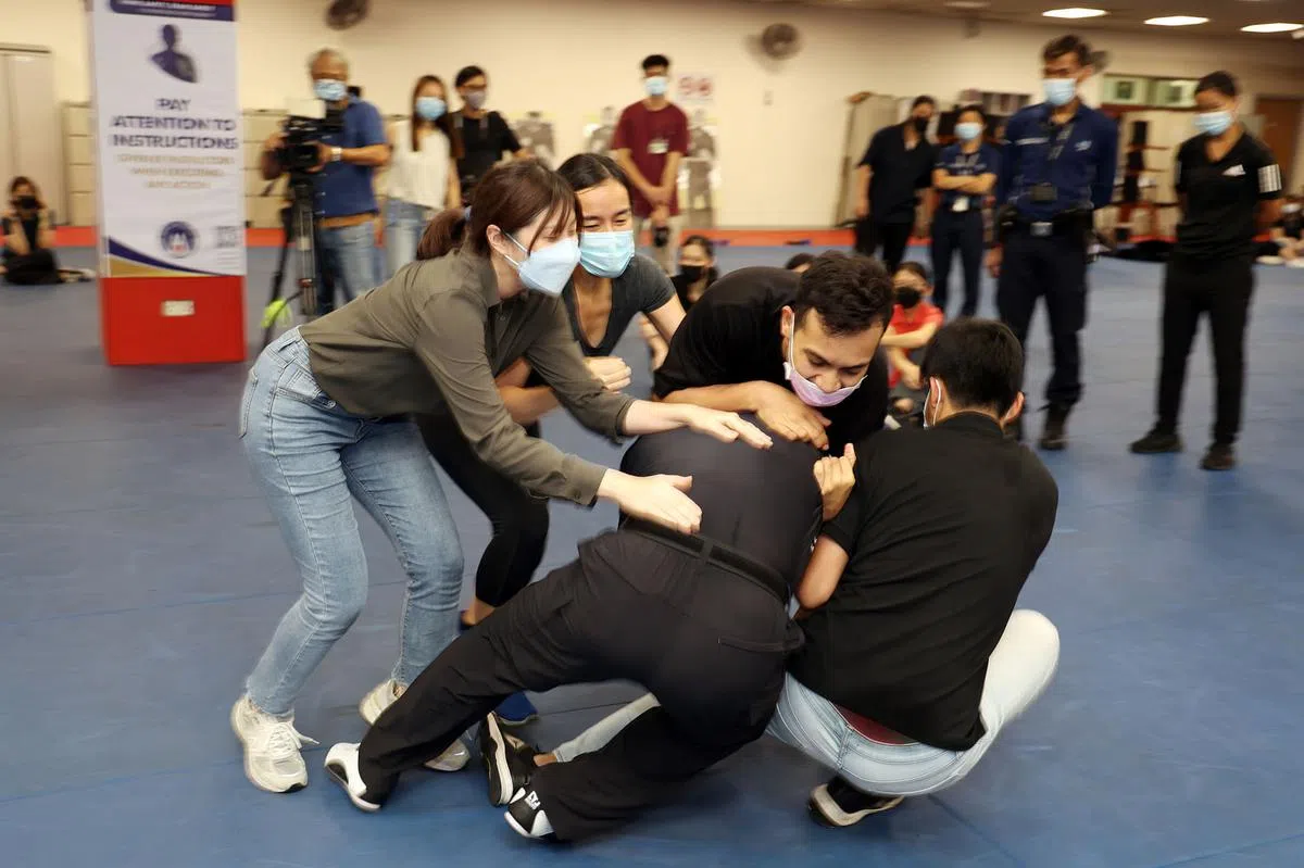 四名记者（两男两女）一拥而上，尝试制伏自称“老头子”的60来岁男教官，可惜最后还是让他挣脱。（王彦燕摄）