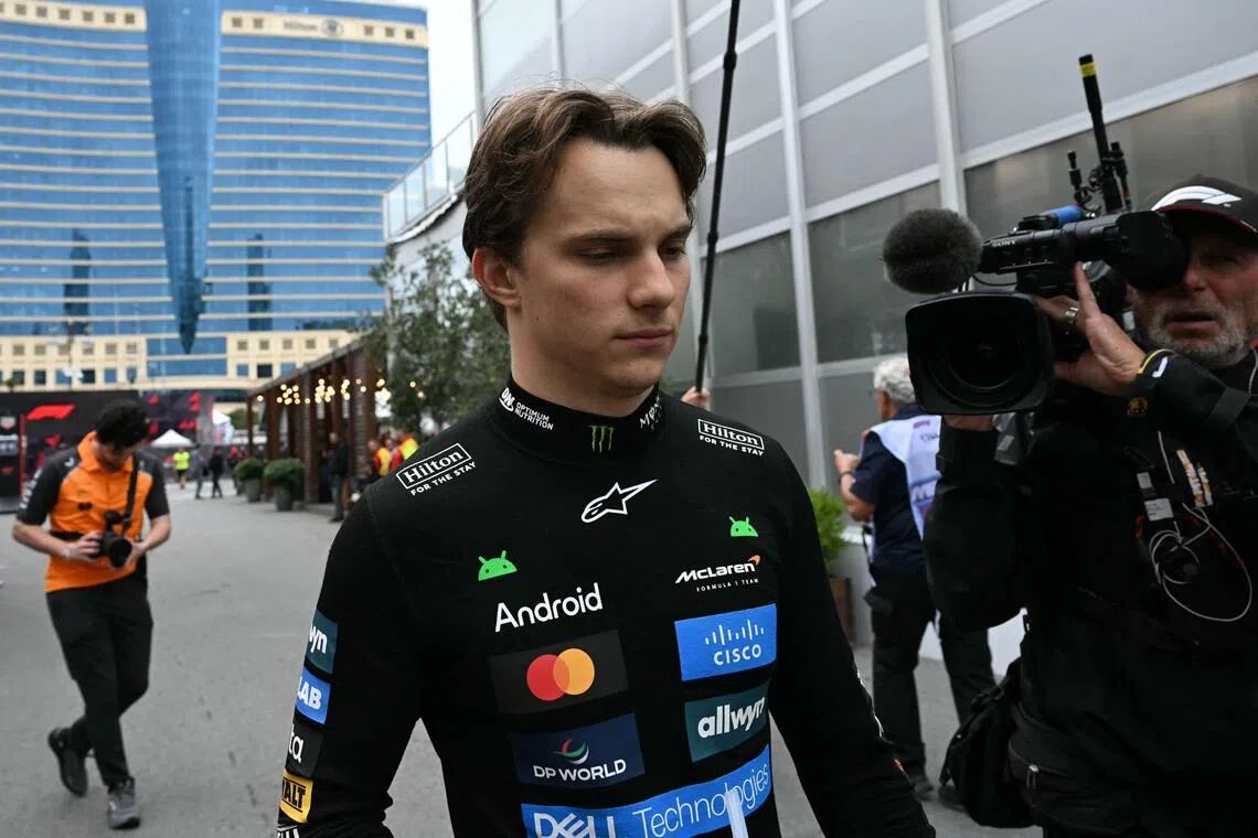 皮亚斯特里（中）在首圈退赛后，只能沮丧地回到车房。（法新社）