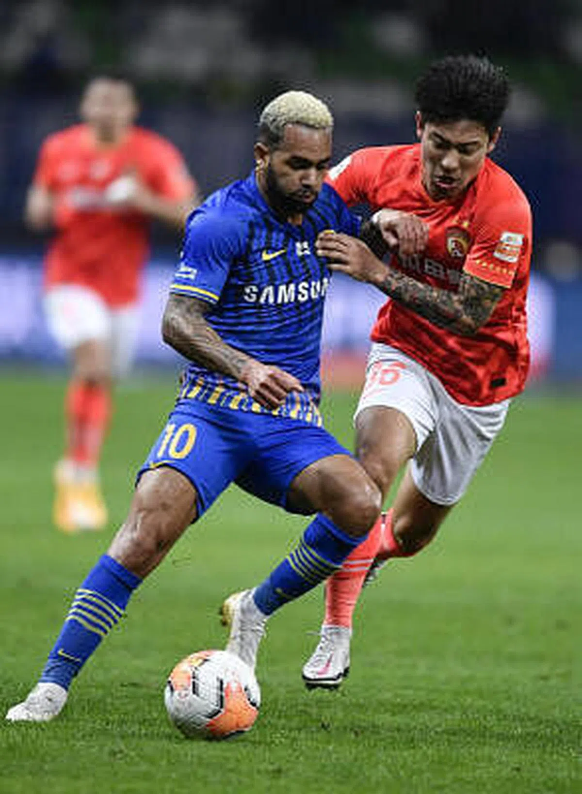 江苏苏宁易购队2020年11月以2比1战胜广州恒大淘宝队，首夺中超联赛冠军，却在隔年宣布解散。图为江苏苏宁易购队球员特谢拉（左）在比赛中带球进攻。（新华社）