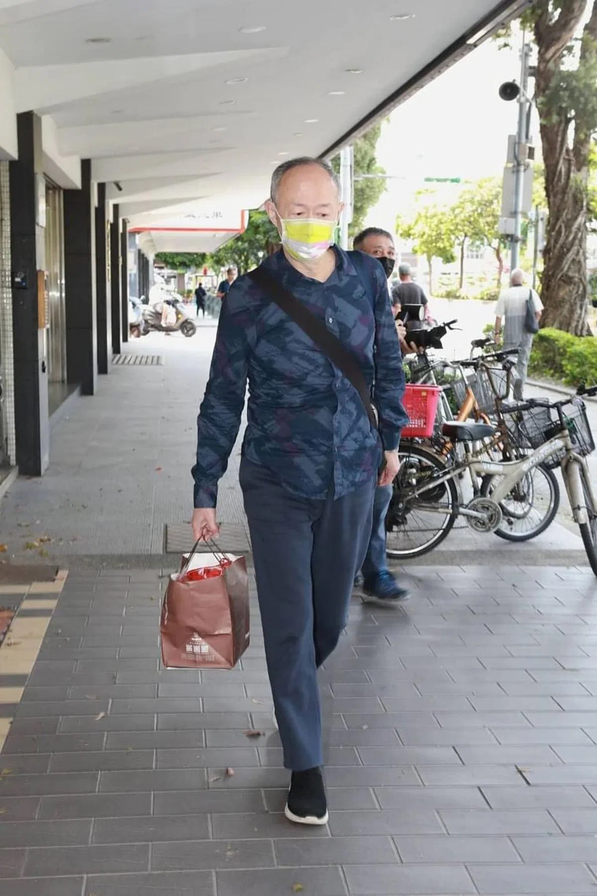 金士杰提着一袋蛋糕到灵堂。（互联网）