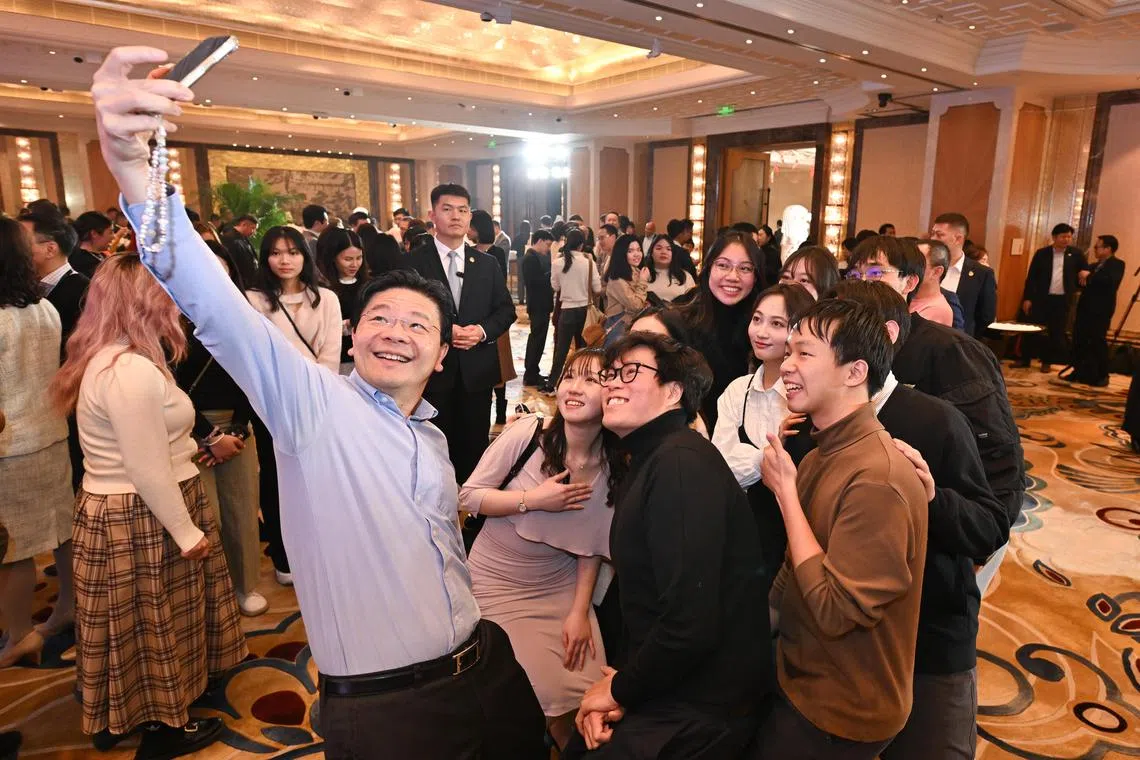 副总理兼财政部长黄循财（前排左一）星期二（12月5日）晚与旅居北京的新加坡人见面，他在招待会上同大家自拍合影。（海峡时报）