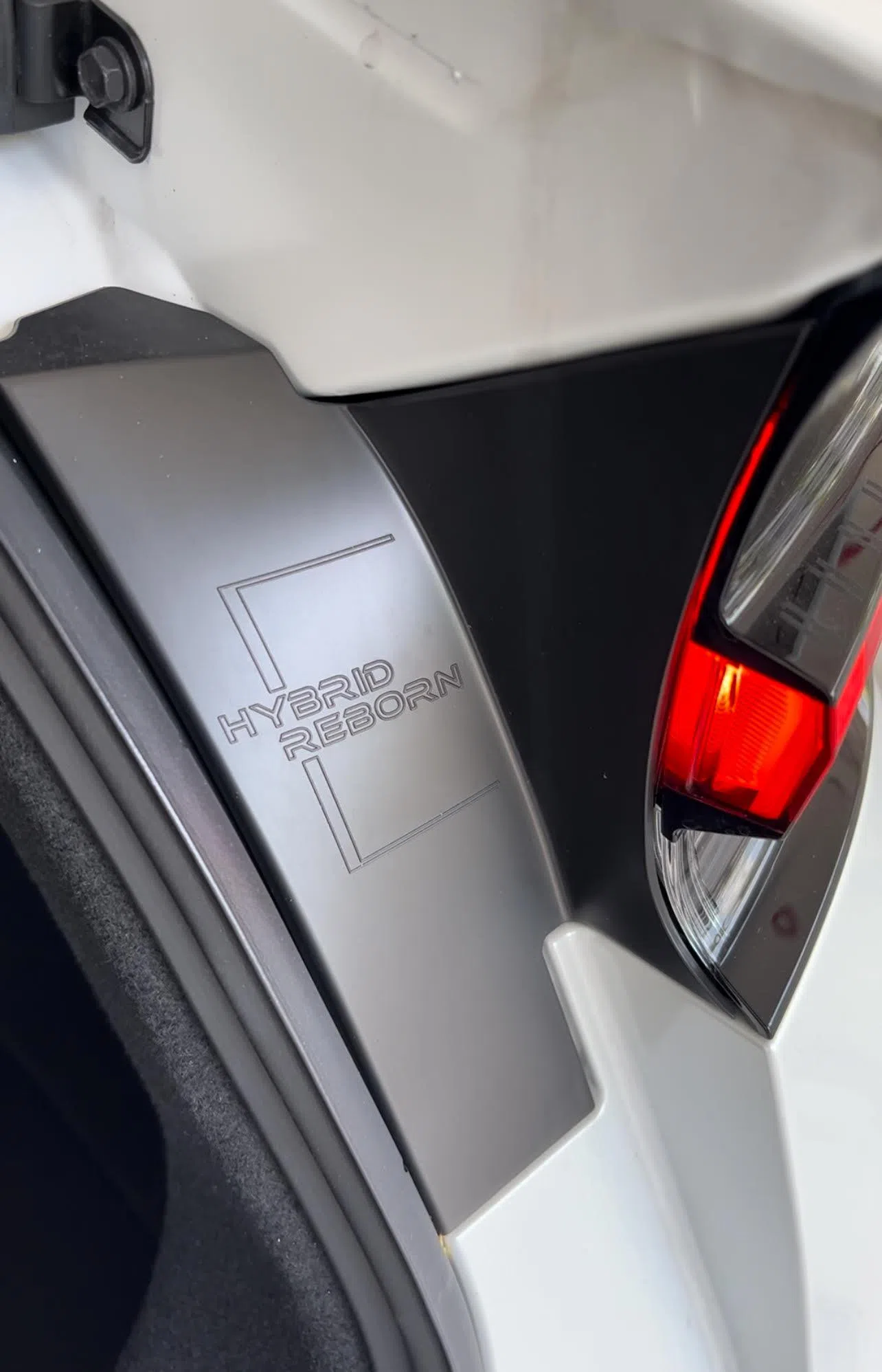 后车厢门右侧刻有“Hybrid Reborn”字样，代表“混动重生”。（黄少伟摄）