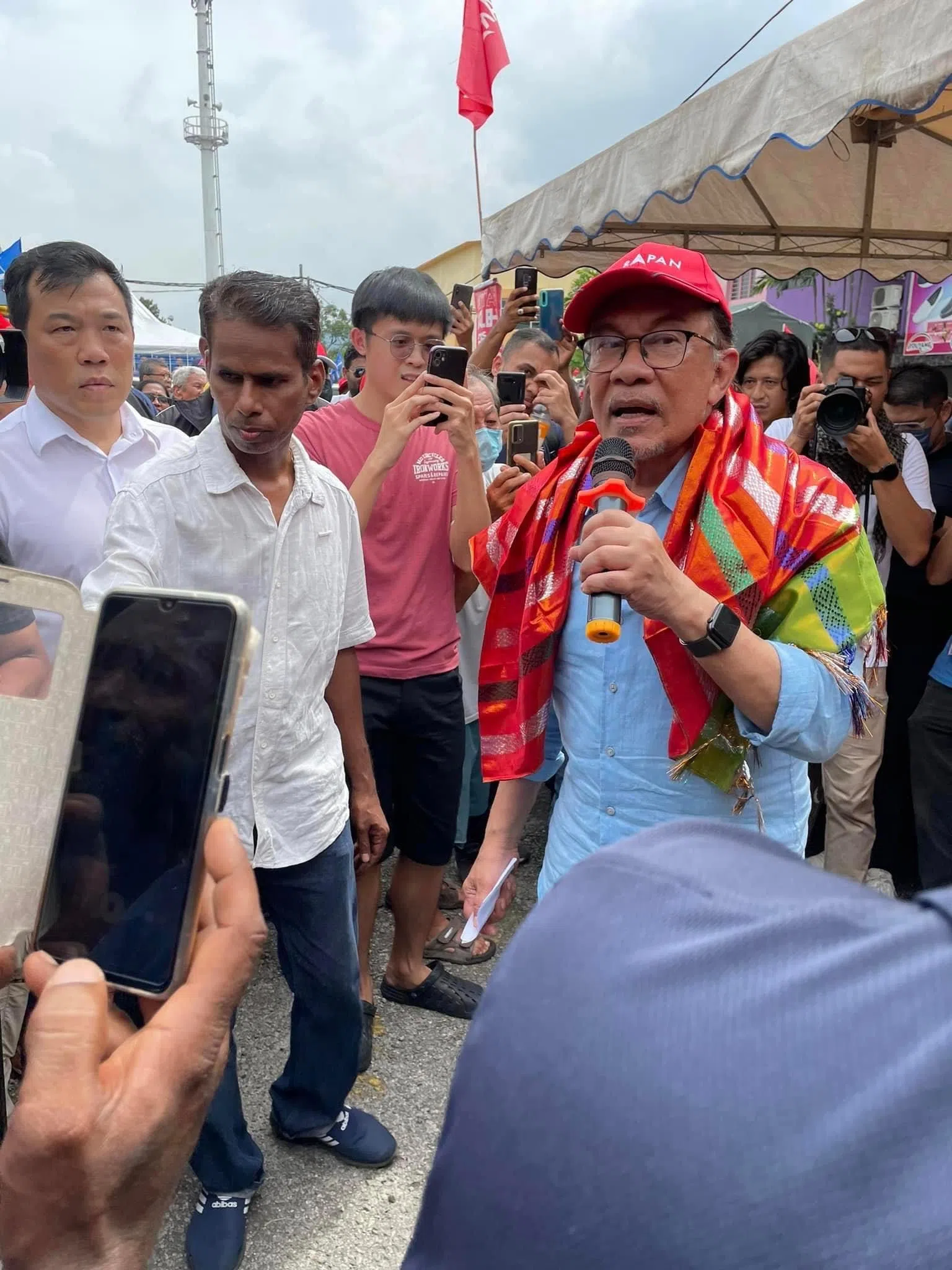 2022年大选，安华（右一）在霹雳州拜票时吸引民众驻足拍照围观。（范晓琪摄）