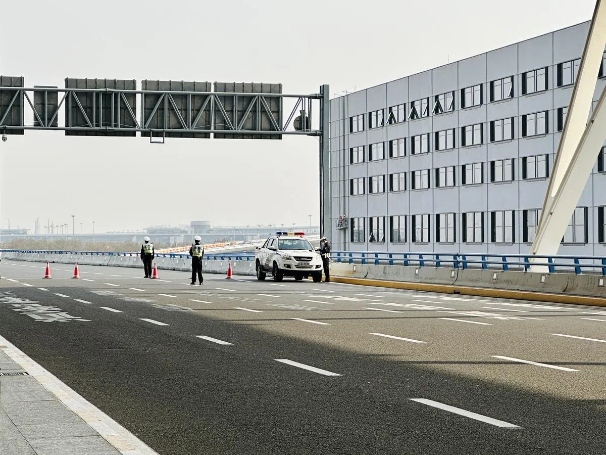 进入浦东机场第二航站楼的车道上增设警车和警员站岗。（陈婧摄）