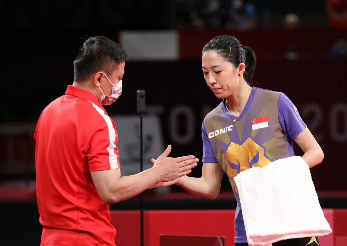 不敌日本女将伊藤美诚，于梦雨在铜牌战后与教练击掌，相互勉励。（邝启聪东京摄）