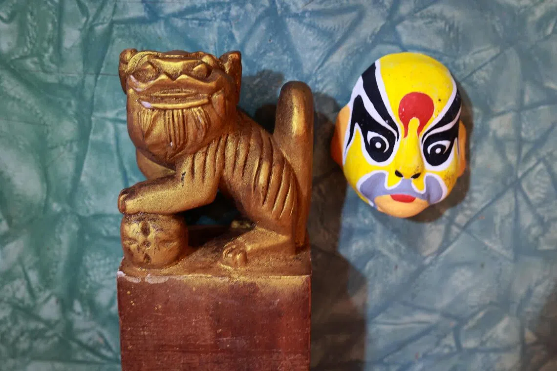 左边的狮子印，是陈贵财小六时的首个木雕成品，右边的迷你纸黏土京剧脸谱则是他中学时的创作。（龙国雄摄）