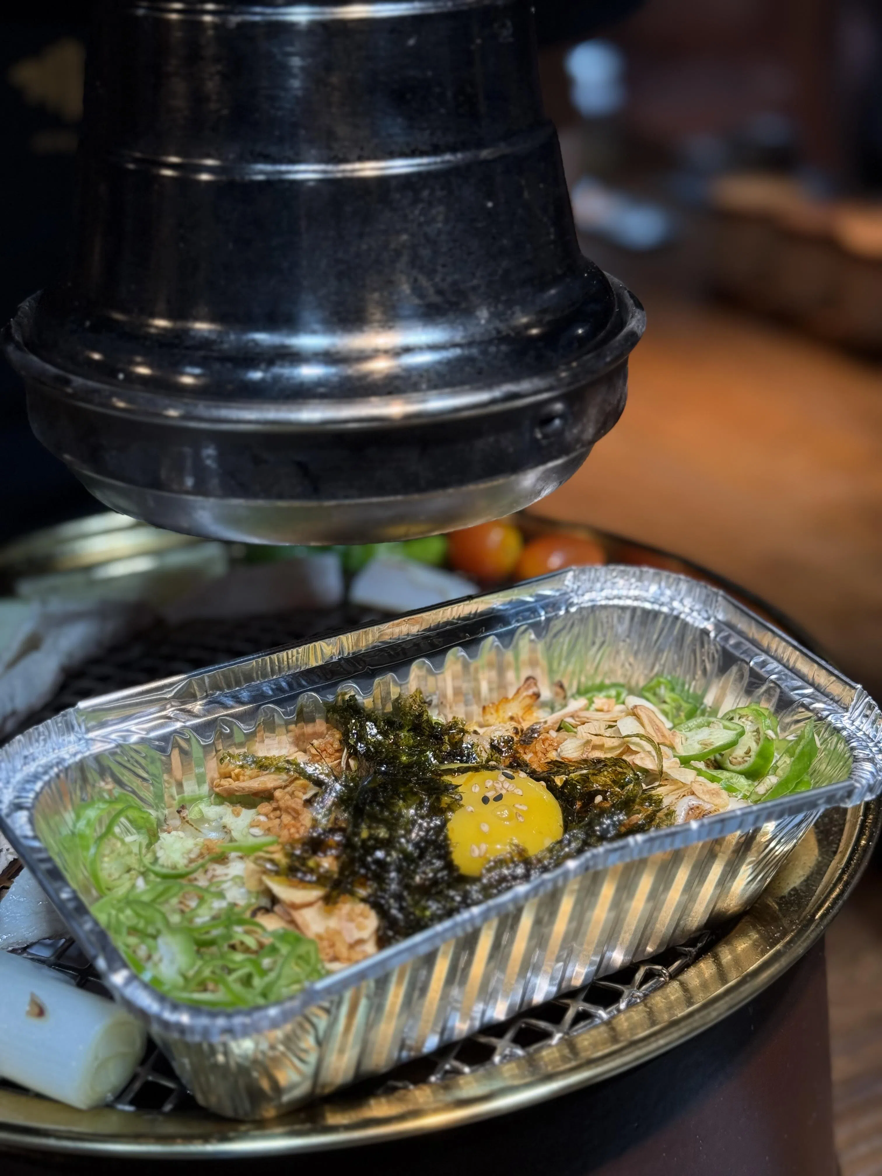 义城蒜片炒饭放在铁盘上加热，待芝士焗烤至融化，再拌以蒜片与辣椒享用。（叶晓虹摄）