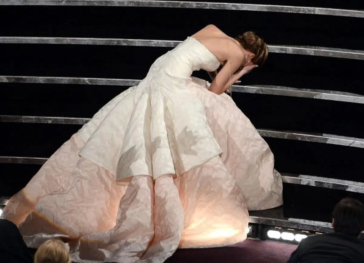 Jennifer Lawrence上台领奖时被礼服绊倒。（互联网）