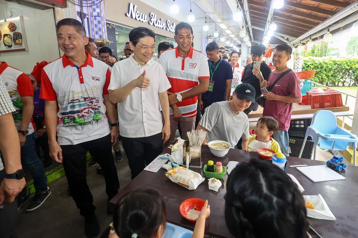 黄循财总理（左二）与宏茂桥集选区议员杰乐（左三）星期六早上走访后港村一带，与居民打招呼问好。（陈渊庄摄）