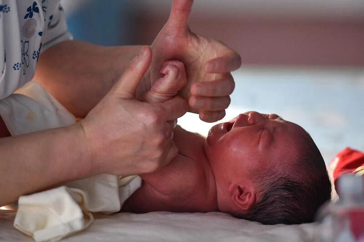 中国安徽阜阳市一家医院的护士，在照顾一名刚出生的婴孩。（法新社）