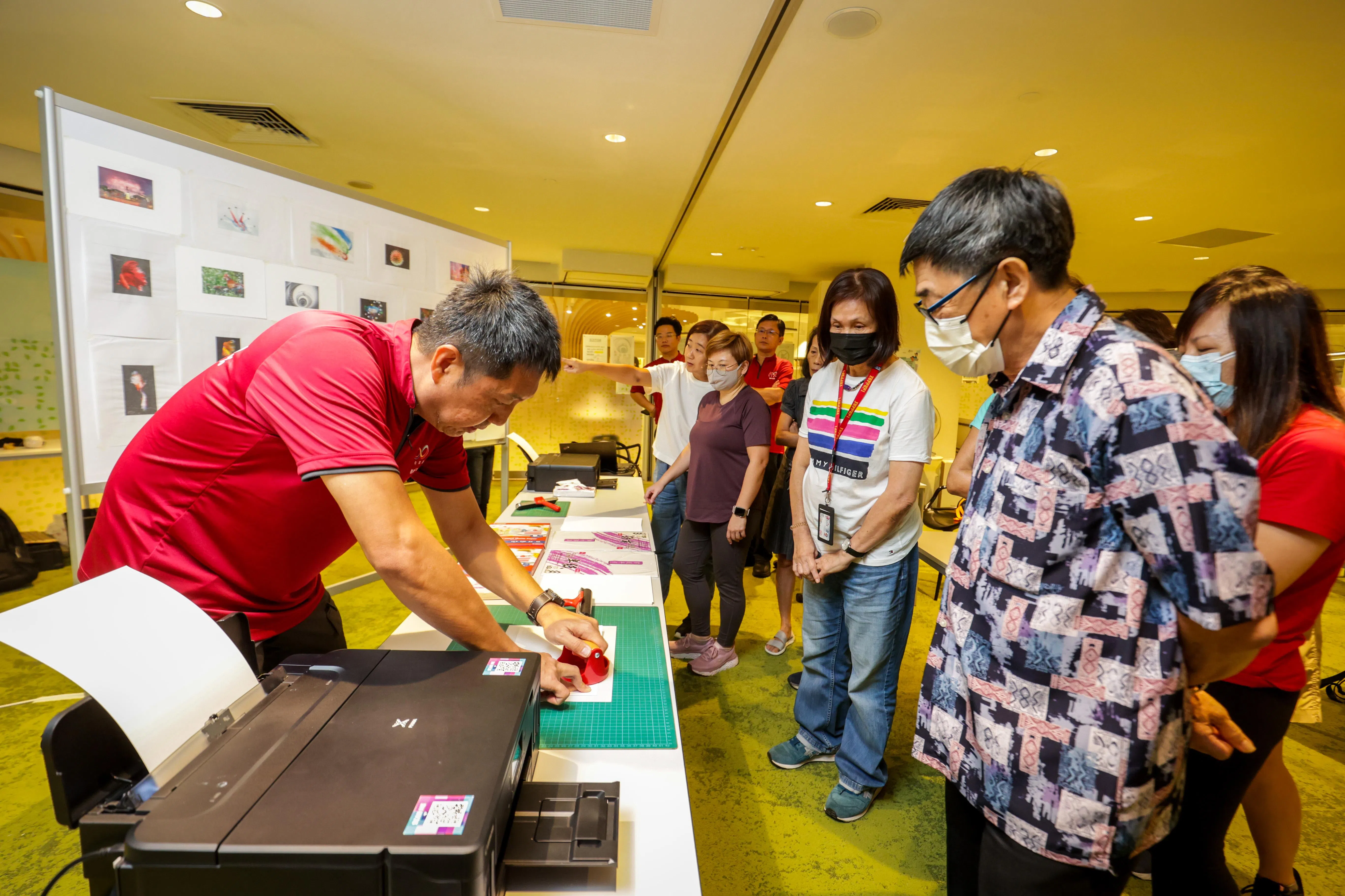 早报摄影记者蔡家增（左）为参加图像转印工作坊的读者示范如何把数码照片转印在宣纸和相纸上。（叶振忠摄）