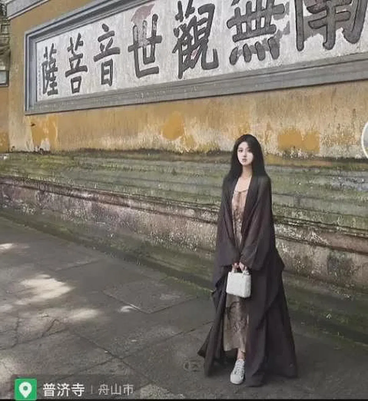 佛媛行程要和“佛”沾边，但这名网红在佛寺中拍照，却敞开僧服露出长裙，还将Dior戴妃包捧在前面。（互联网）