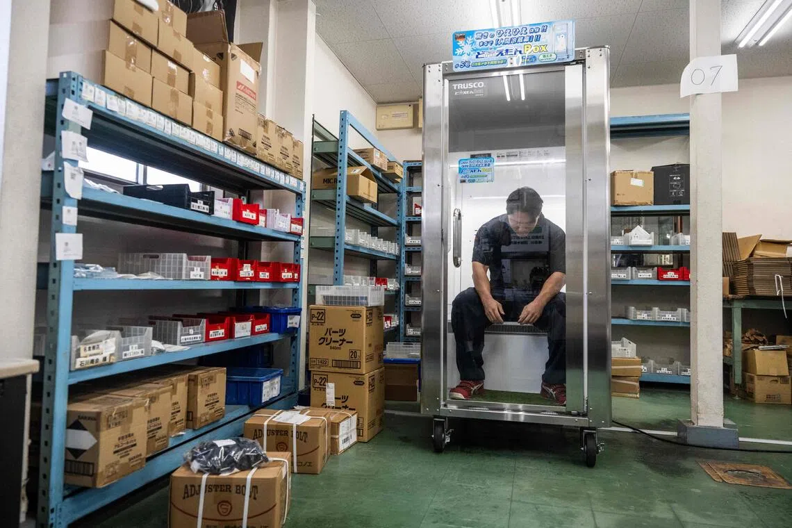 搬运工人小西太一每天得徒手搬运沉重的金属工具和零件箱，一天会进入“人用冰箱”休息三次。（法新社）