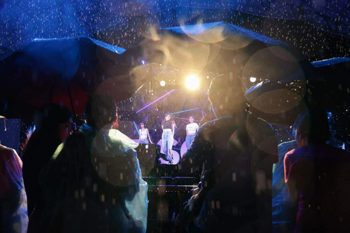 民众在雨中撑伞观看义顺集选区的跨年活动表演，倒数兴致不减。（李冠卫摄）