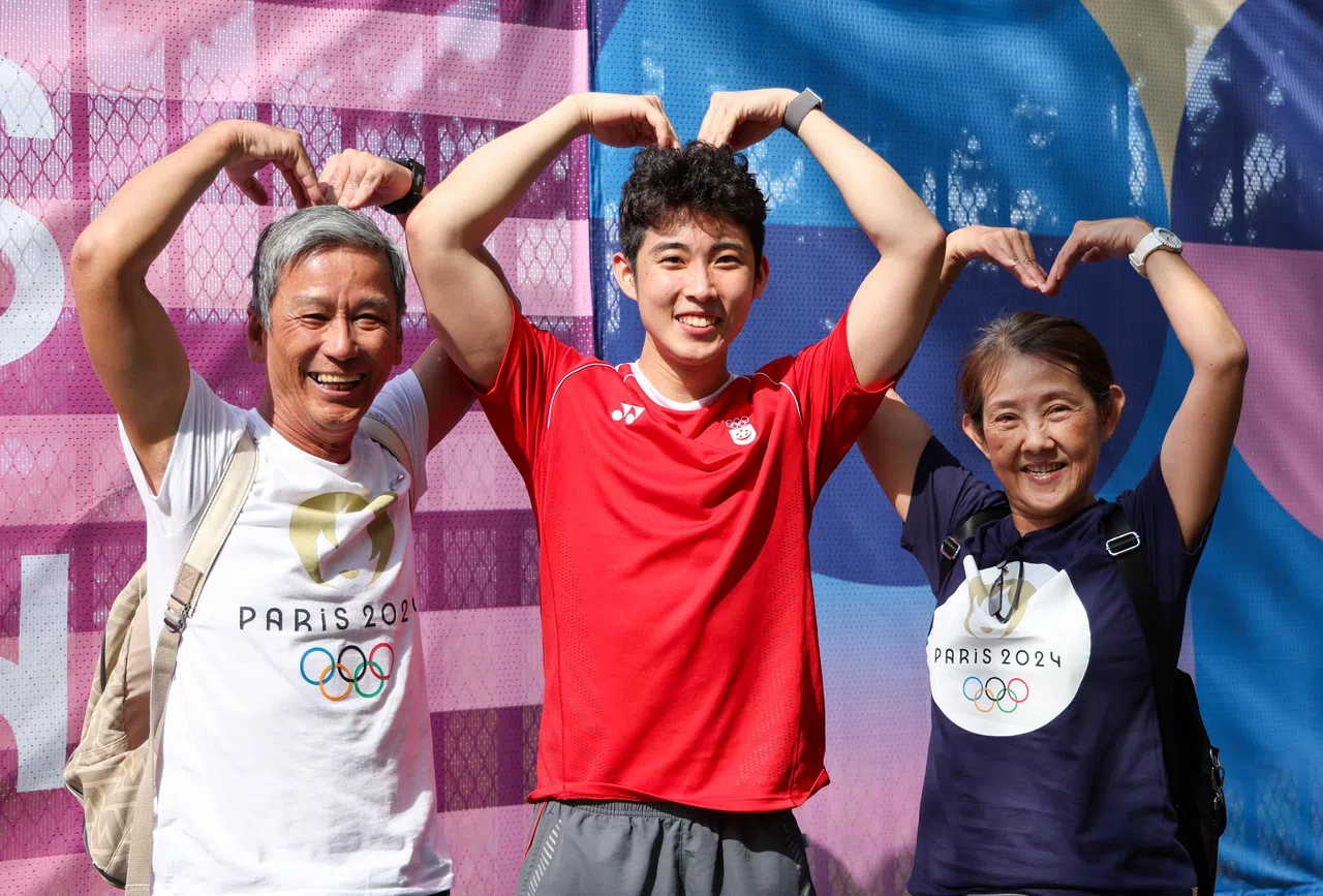 骆建佑（中）在拉夏贝尔门体育馆（La Chapelle Arena）赛场外和父母一同“比心”合影。（新加坡体育理事会提供）