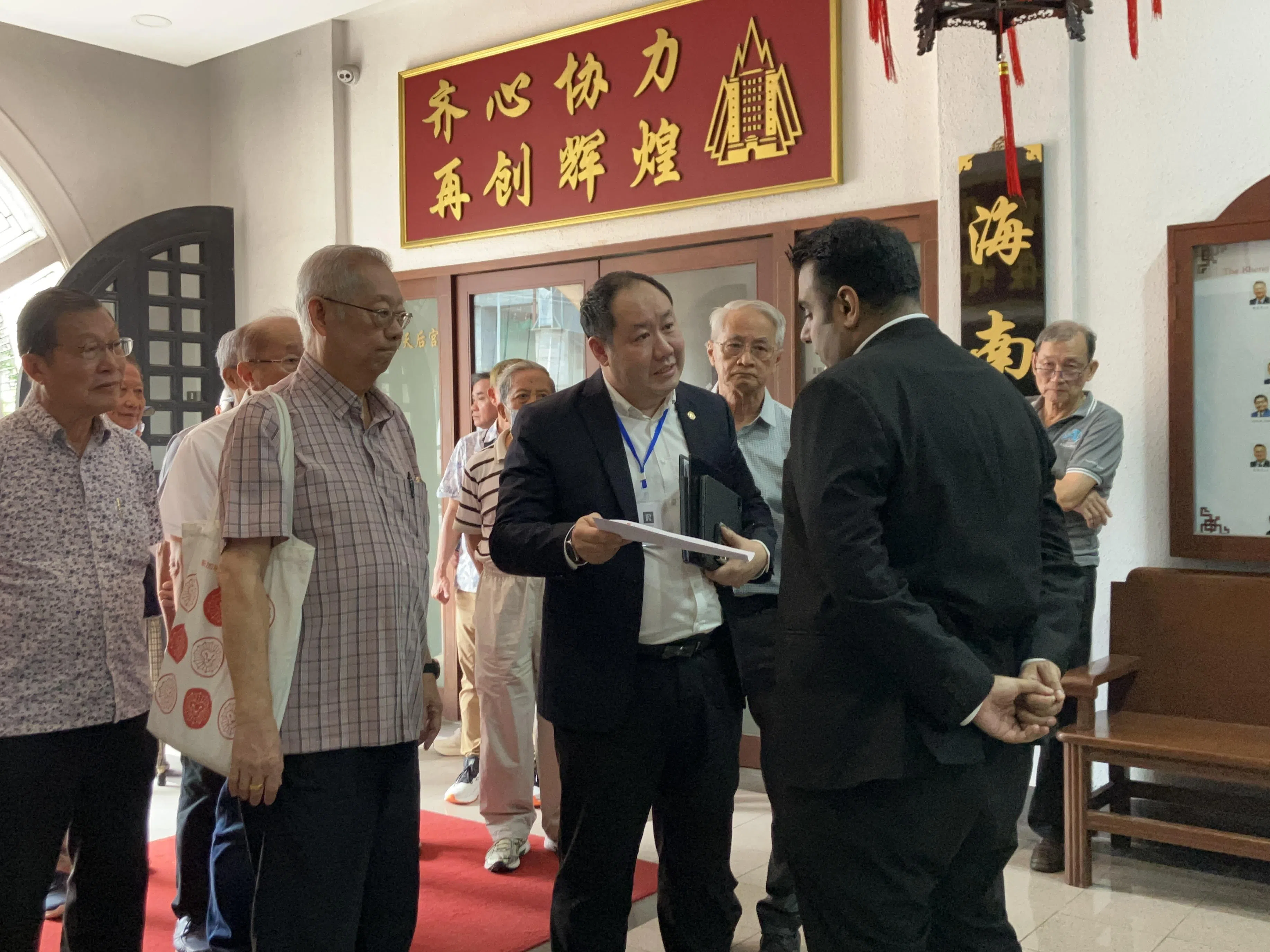 琼州天后宫新当选主席王振胡（前排左起）和萧锦耀律师与符永平律师Rajwin在琼州大厦一楼交涉。（张鹤杨摄）
