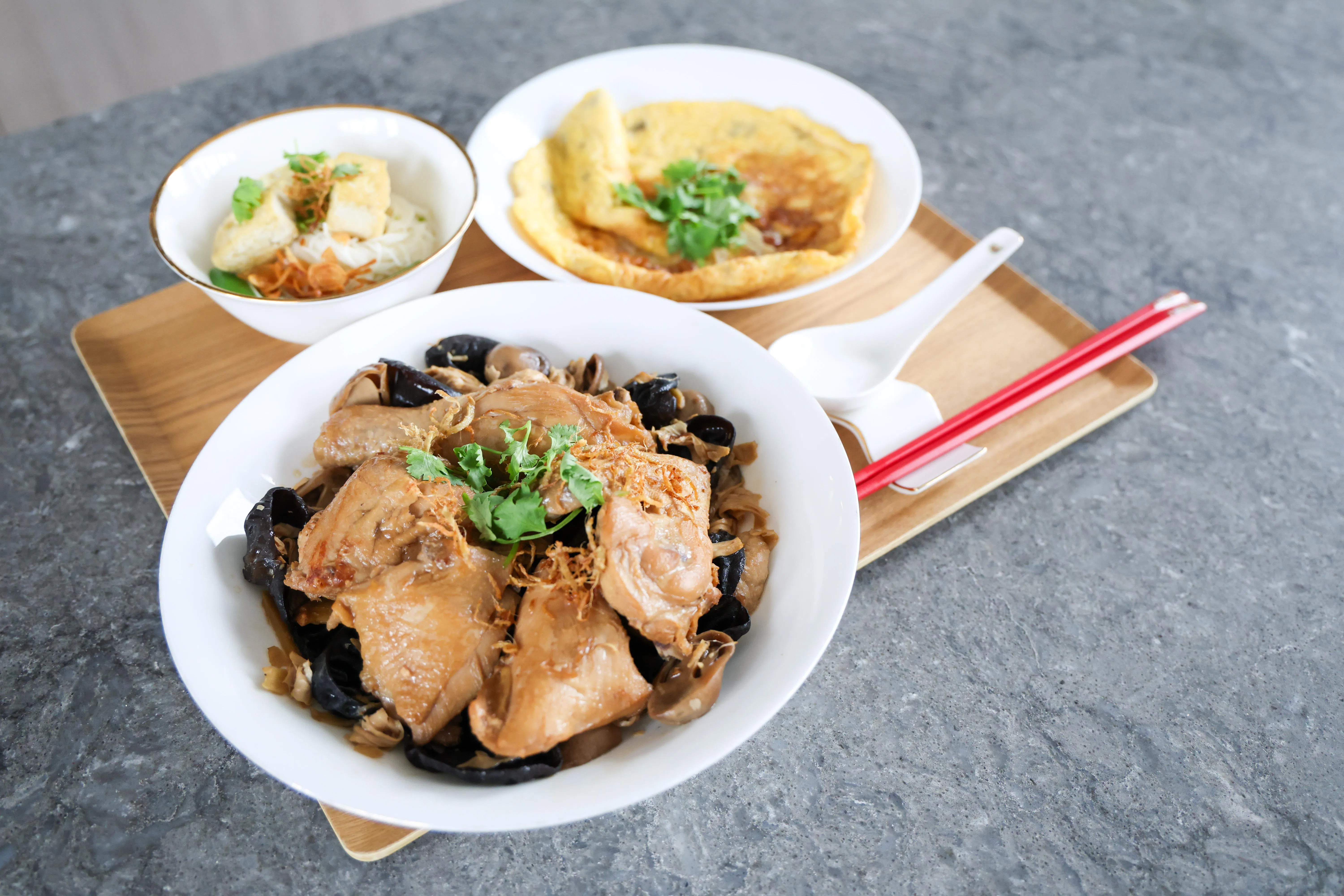 家常菜如黑木耳麻油鸡（前）、麻油煎蛋（后右）及麻油鸡蛋面线（后左），烹调时加入几滴芝麻油，不仅香气四溢，更添美味。（陈斌勤摄）