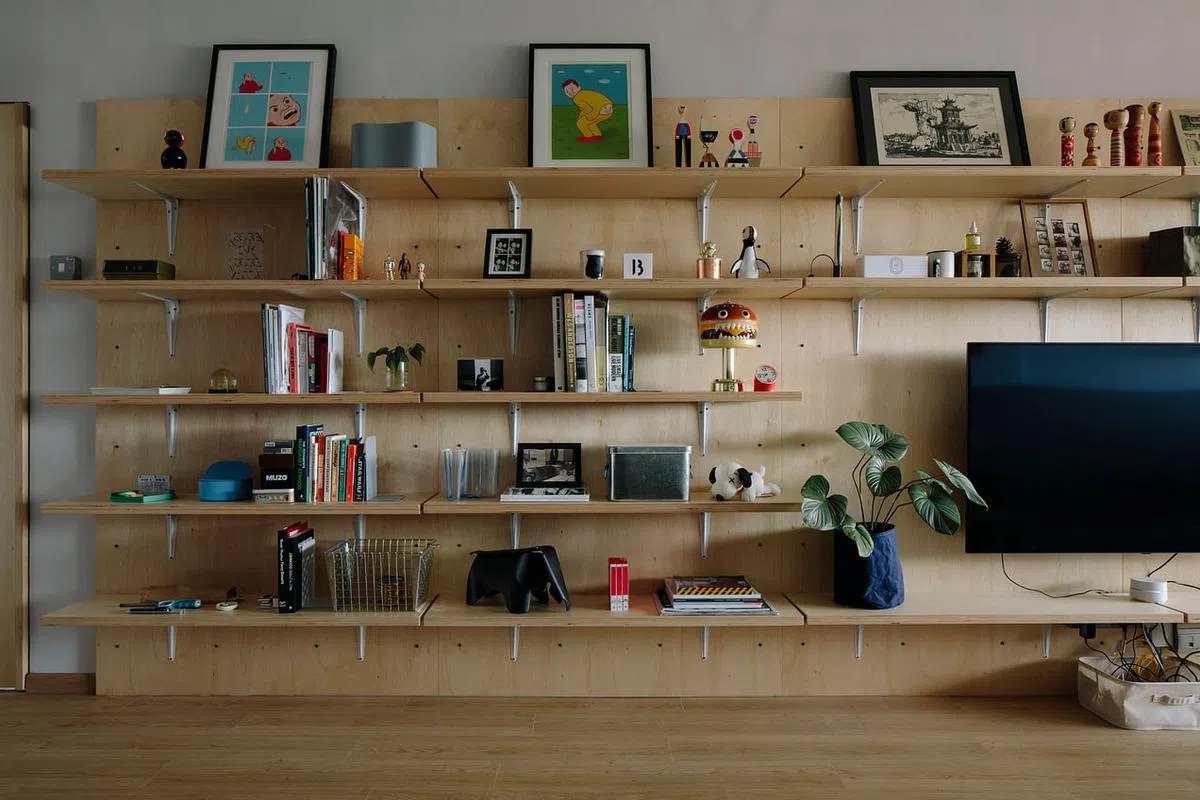 设计师用L形铁托架和木板在一大片木板上分隔成五层的书架、橱架，是屋主展示收藏的舞台。