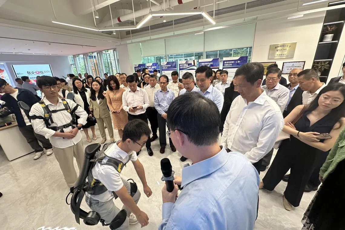 新加坡卫生部长王乙康（右二）在中新智慧园参观新加坡国立大学广州创新研究院，并观看了一场辅助外骨骼机器人的示范。（林煇智摄）