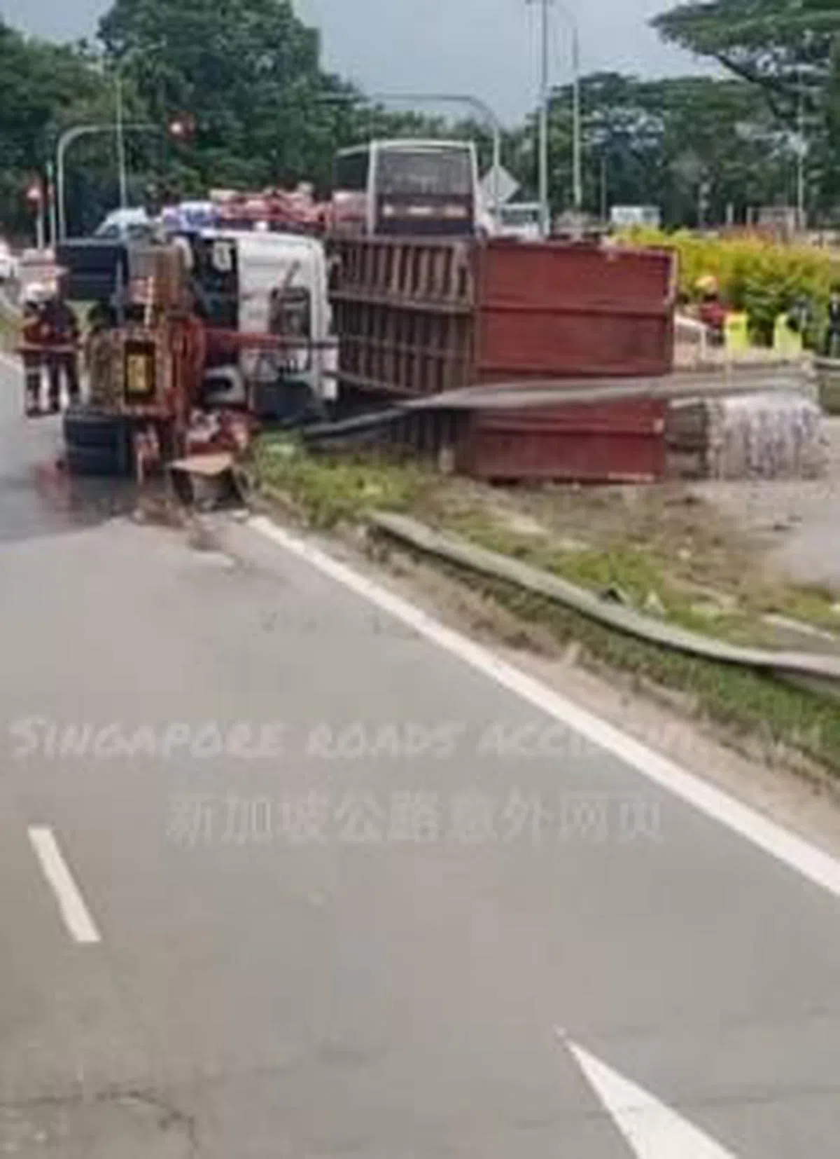 一辆红色卡车在海军部西路翻覆，车厢倒落在反方向的路段。（取自新加坡公路意外网页面簿）