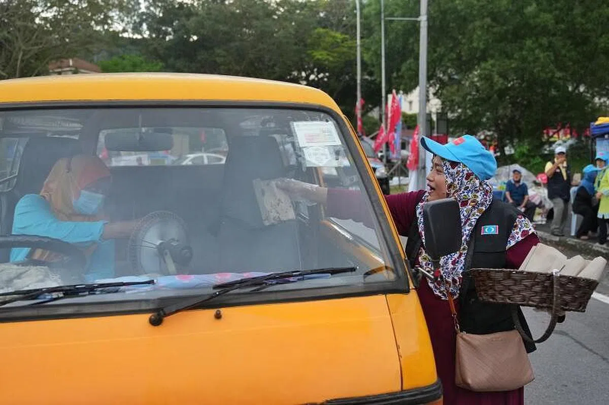 公正党雪州班登国席候选人拉菲兹的竞选团队，在路边摆摊炸香蕉，再派送给路过的民众，展现与众不同的竞选方式。（谢智扬摄）