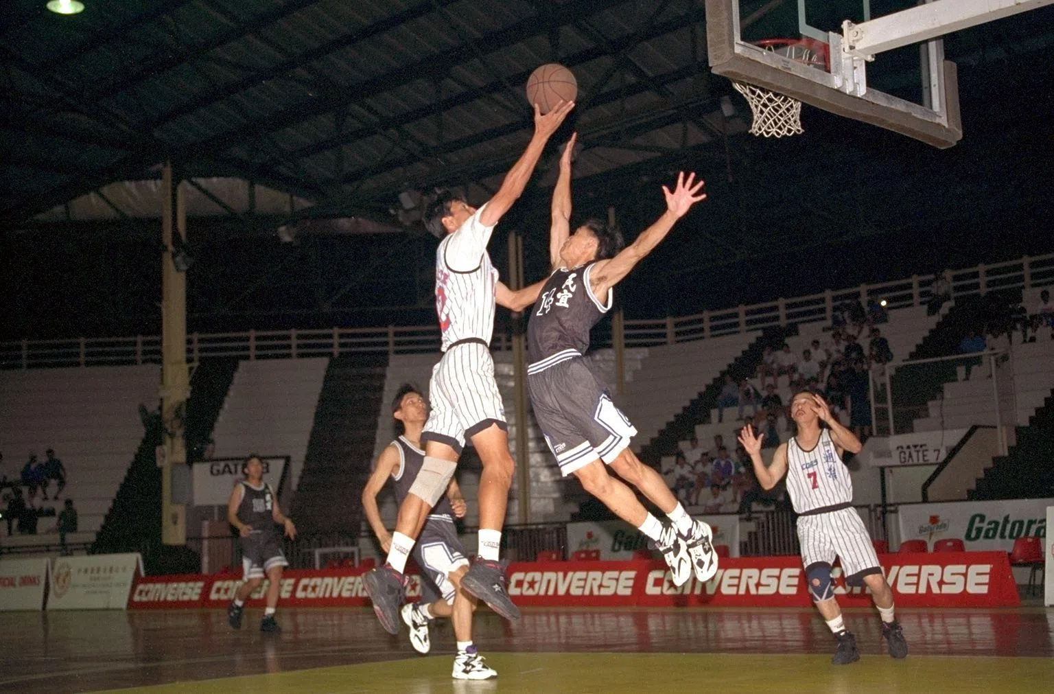 张学雷（左）在1994年代表通淮参加篮总杯甲组篮球赛时，尝试上篮。（档案照片）