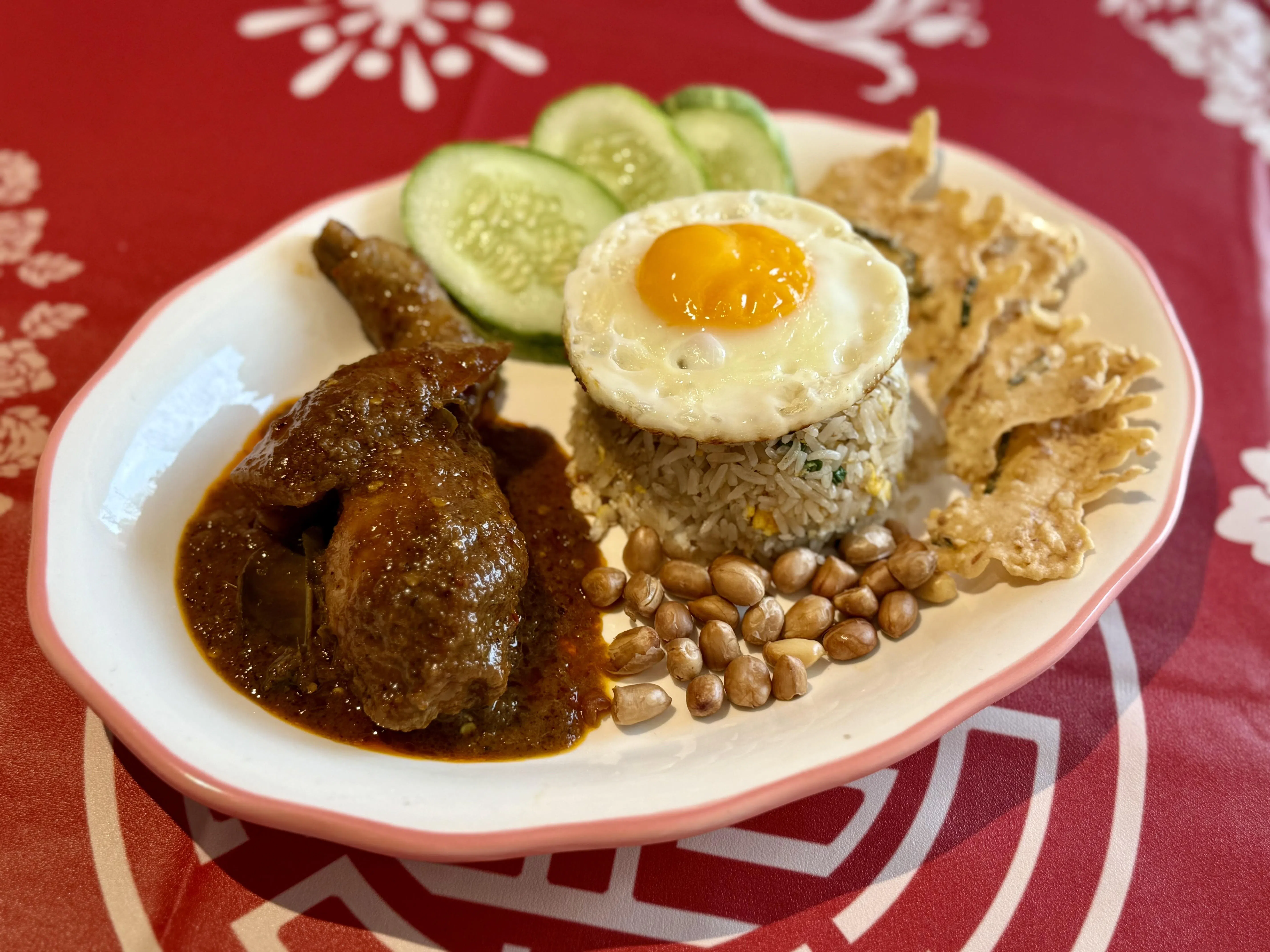 仁当鸡炒饭卖相十足，搭配马铃薯、煎蛋、花生、黄瓜，以及自制天贝脆饼。（叶晓虹摄）