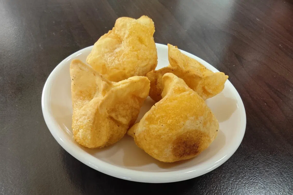 油炸黄金饺是马祖传统的番薯甜点小吃，香脆之外，还可以嚼到里面的花生、芝麻和白糖。（梁丽庭摄）