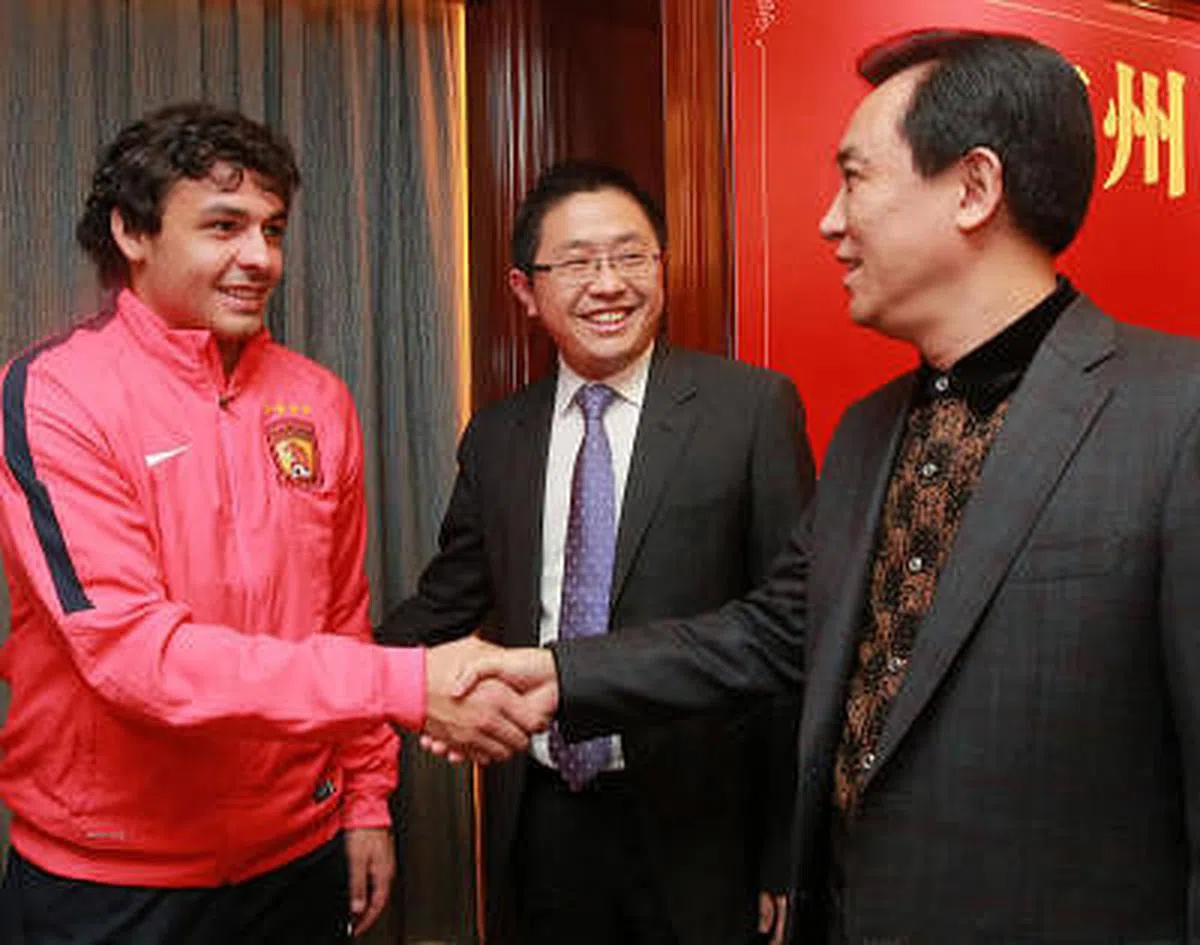 许家印2010年以1亿元（人民币）抄底广州足球，正式拉开了金元足球序幕。他在2015年的会上定下一定要夺亚冠冠军的目标。图为许家印（右）和外援高拉特（左）握手。（新华社）