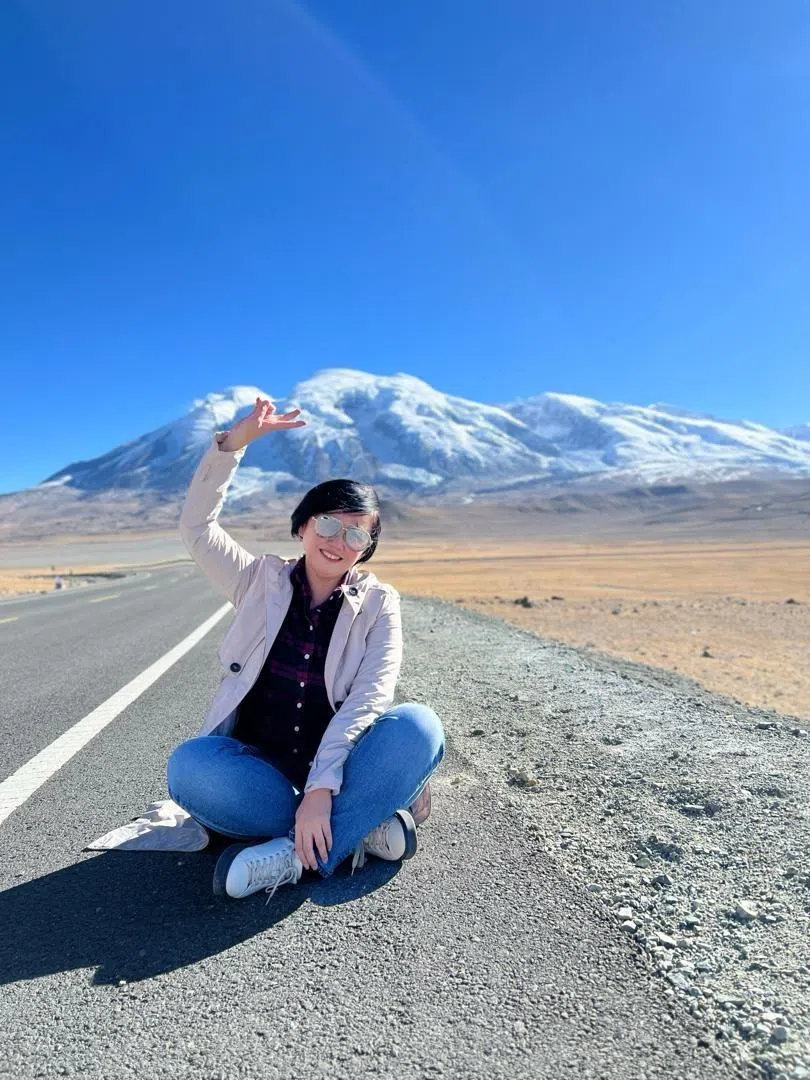 中国旅游最令邓丽君印象深刻的是新疆。图为邓丽君在前往南疆帕米尔高原路途中，背景为慕士塔格峰。（受访者提供）