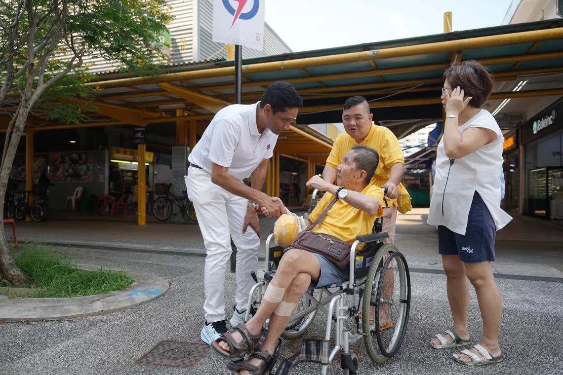 虽然才刚调往东海岸集选区不久，区内已有一些居民认得出迪内希（左），与他打招呼。（谢智扬摄）