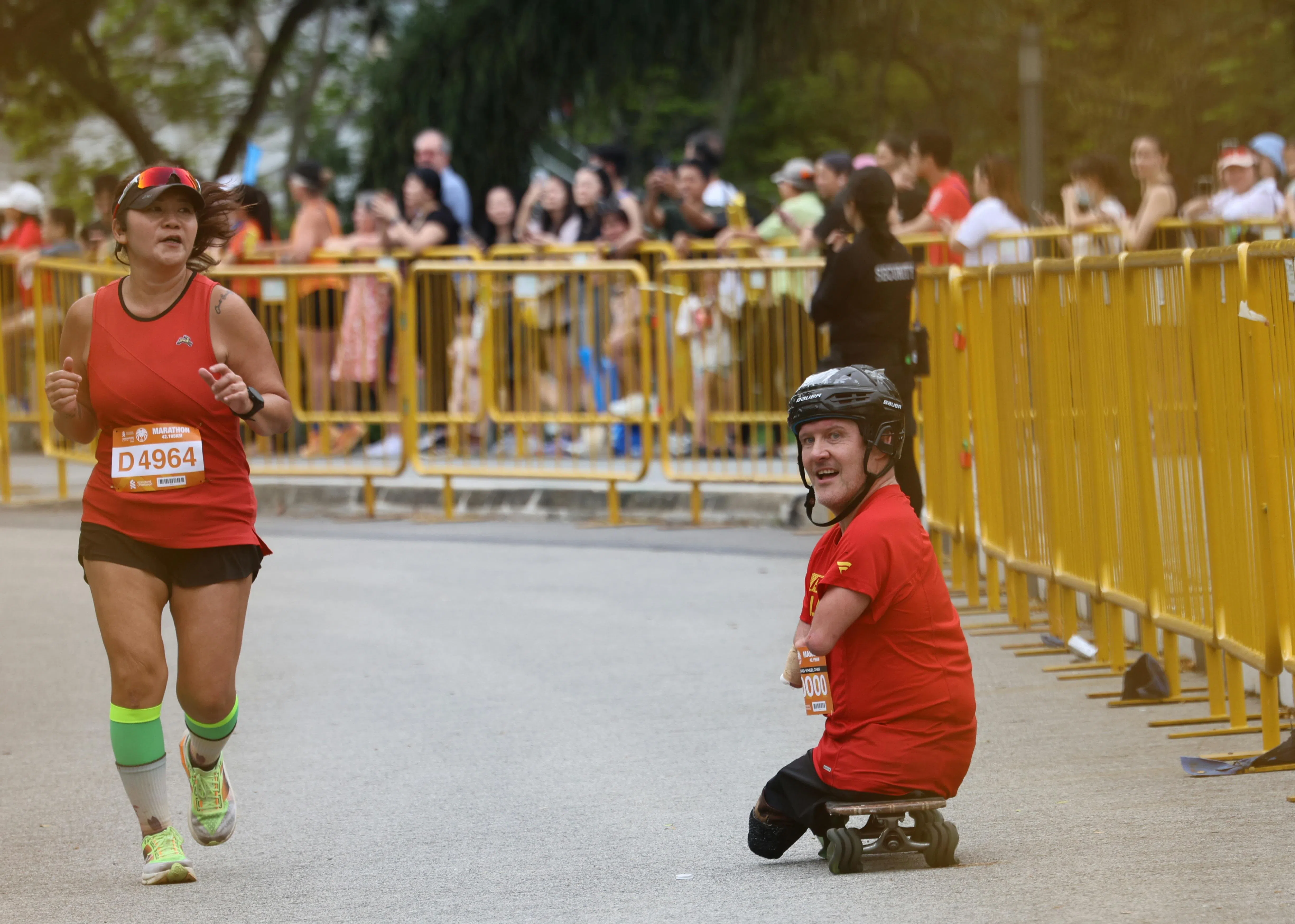 天生四肢不全的加拿大选手克里斯·科赫（右）继前一日借助滑板完成半马比赛后，在全马比赛中以4小时20分05秒的成绩再度成功完赛，不少人为他加油喝彩。（梁麒麟摄）